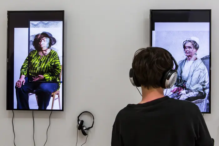 Ein Besucher hört im Kopfhörer ein Audio eines Ausstellungsexponats. 