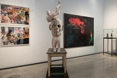 Ausstellungsraum mit Skulptur und Bildern