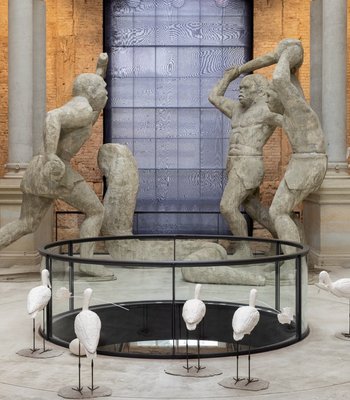 Raum mit Backsteinwänden und großen Statuen