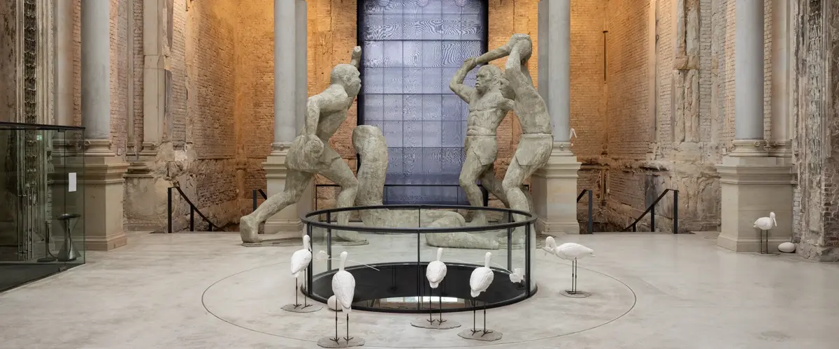 Raum mit Backsteinwänden und großen Statuen