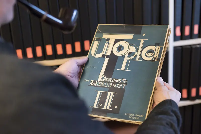 Ein Mann hält ein Buch mit einem avantgardistisch gestalteten Einband