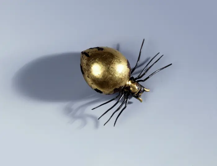 goldene Spinnenfigur