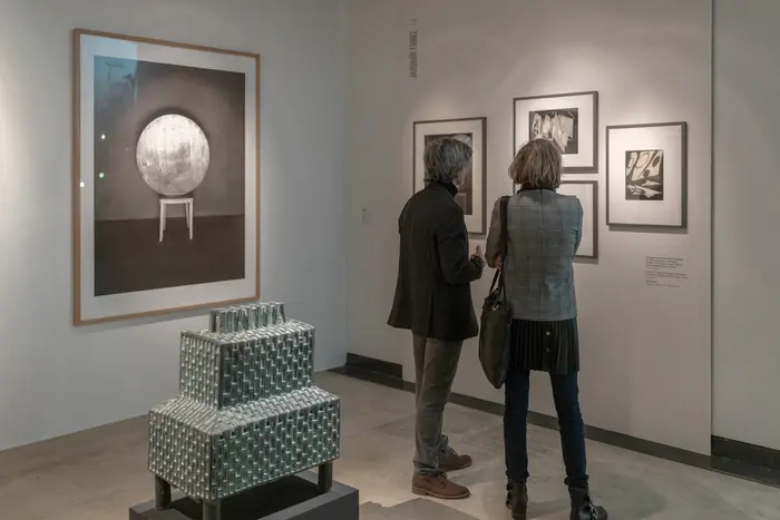 Ausstellungsansicht "Alle Macht der Imagination!" Menschen betrachten Fotos in einer Ausstellung